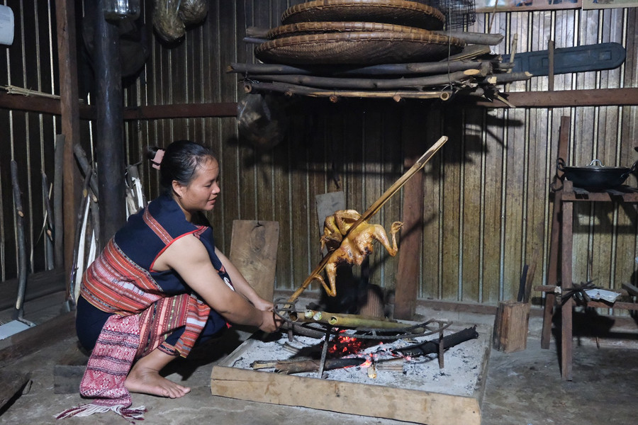Ms. Đinh Thị Nhung (Stơr Village, Tơ Tung Commune) grills chicken to welcome guests. Photo: Hoàng Ngọc dscf5130.jpg