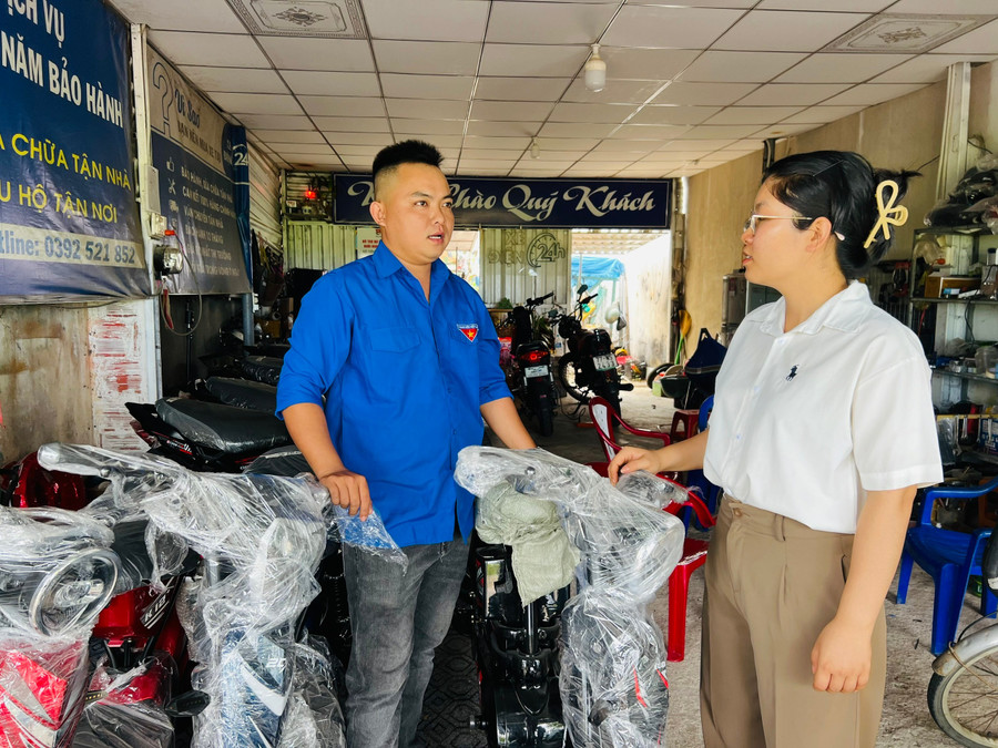 Mr. Trần Chiến Thắng (far left, An Cửu hamlet, Tuy Phước Bắc commune) shares his journey of starting a business with an electric bicycle sales and repair shop. Photo: M.N anh-2.jpg