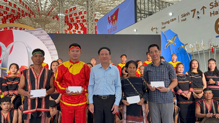 Chairman of the Provincial People’s Committee Phạm Anh Tuấn (front row, third from right) presents gifts to artisans and those who are participating in the exhibition. Photo: Thành Hưng 1.jpg