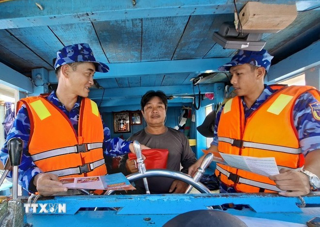 Law enforcement officers of Ho Chi Minh City disseminate anti-IUU fishing regulations to a fisherman. Photo: VNA