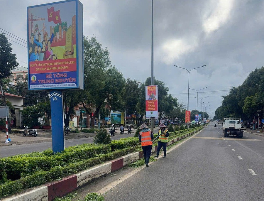 Workers from Gia Lai Urban Joint Stock Company tending to greenery along urban traffic routes. cong-nhan-cong-ty-co-phan-do-thi-gia-lai.jpg