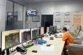 Night-shift workers monitor equipment operations at the An Khê Hydropower Plant. Photo: Văn Cường