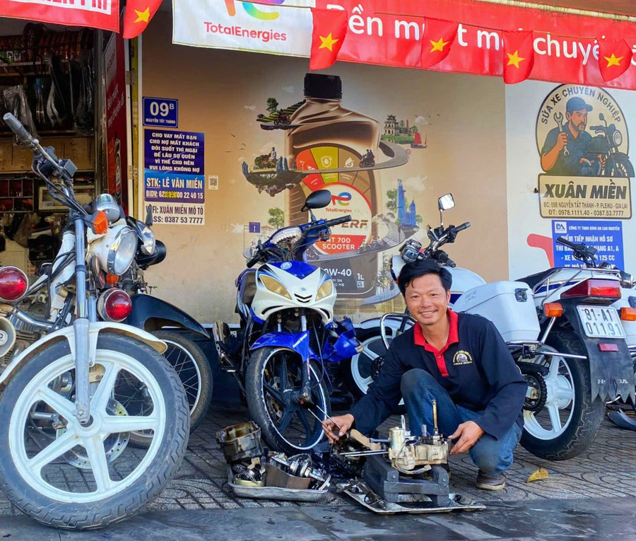 anh-le-van-mien-tranh-thu-sua-xe-may-cho-khach-sau-buoi-dap-xe-sang-anh-dong-lai.jpg