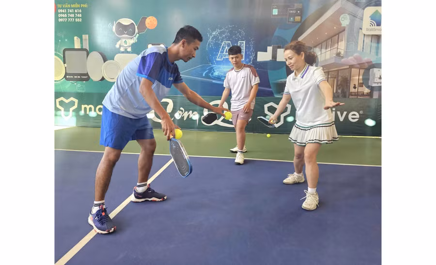 Coach Nguyễn Văn Hùng (left) instructs students in pickleball practice. Photo: R’Ô HOK
