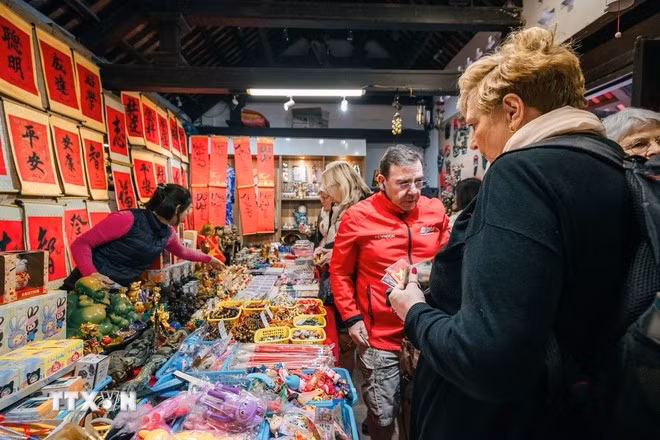 Foreign visitors shopping for souvenirs in Hanoi. (Photo: Pham Tuan Anh/VNA)
