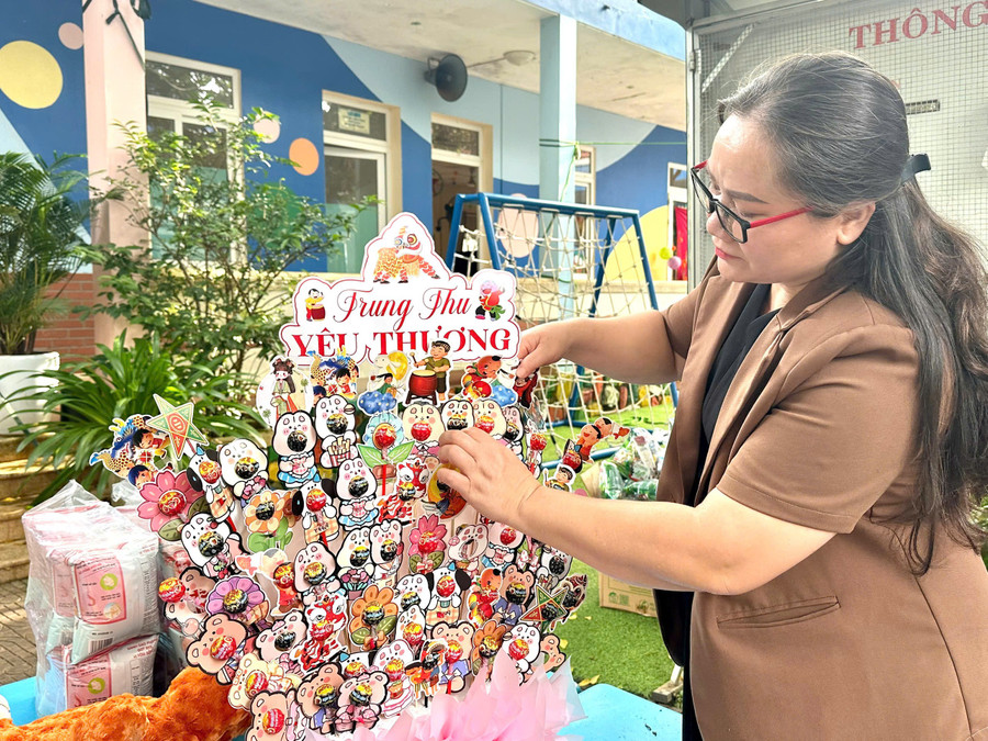 Ms. Nay Hkram (mother of the "Hoa Tuong Vi" family, SOS Children's Village Pleiku) arranges a tower of sweets for the children. Photo: Minh Chi chi-nay-hkram-lang-sos-pleiku-sap-xep-thap-banh-keo-don-tet-trung-thu.jpg