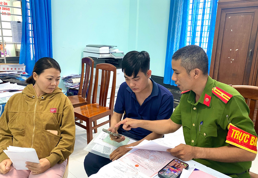 Officers from An Nhơn Nam Ward Police guide and assist residents in registering permanent residence for their children via the VNeID application. Photo: Nguyễn Chơn dang-ky-thuong-tru.jpg