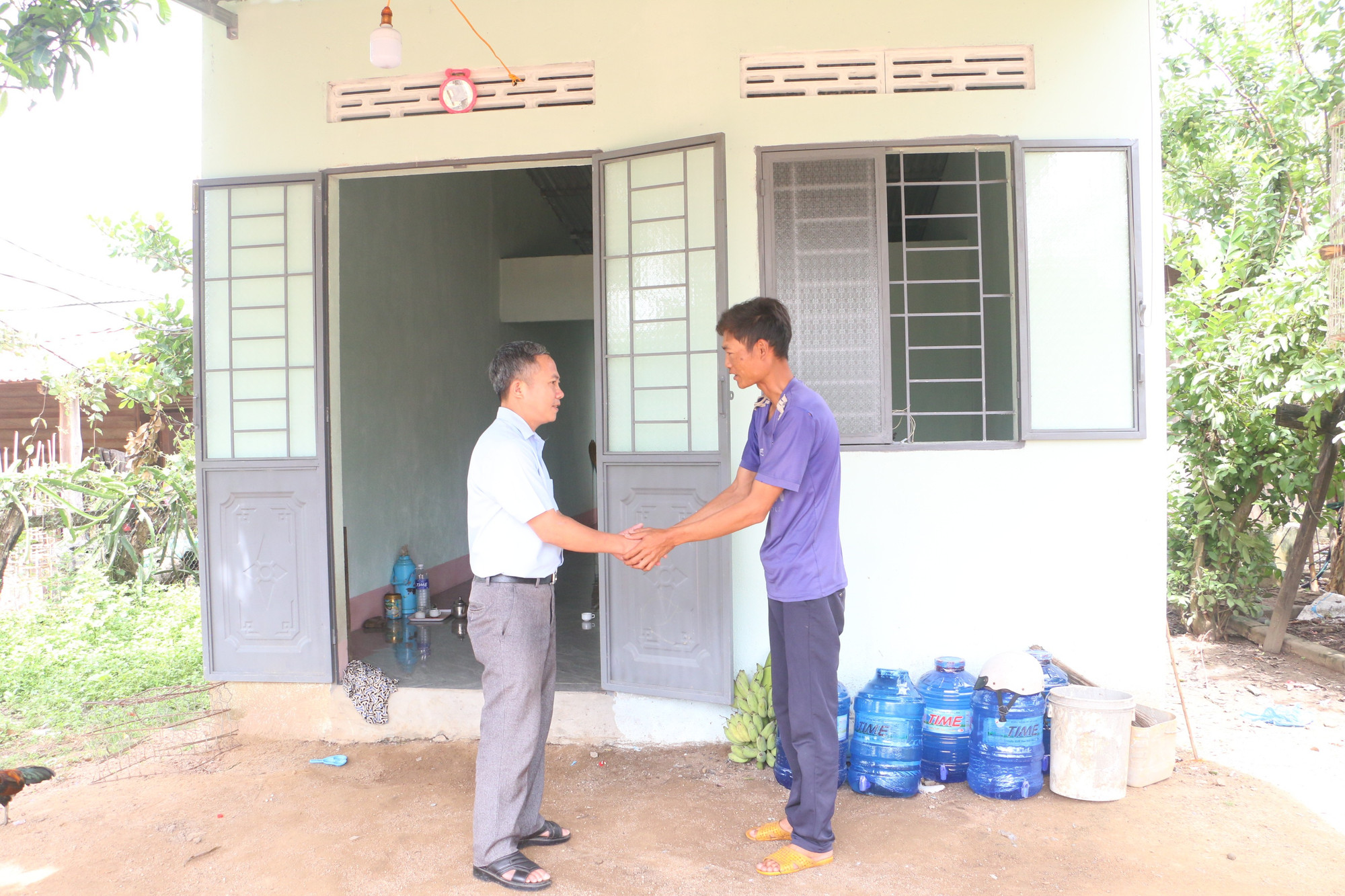 Hà Văn Thự (right) beside his new home. Photo: Quang Tấn ngoi-nha-cua-anh-ha-van-thu-da-khang-trang-vung-chai.jpg