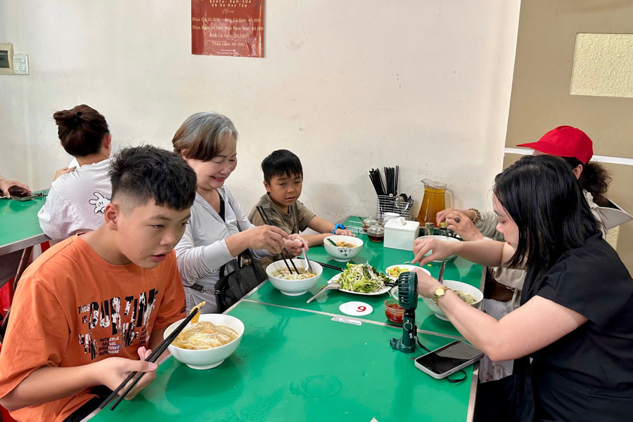 Ms. Xuan (in white) enjoying fish noodle soup with her family. img-8127.jpg