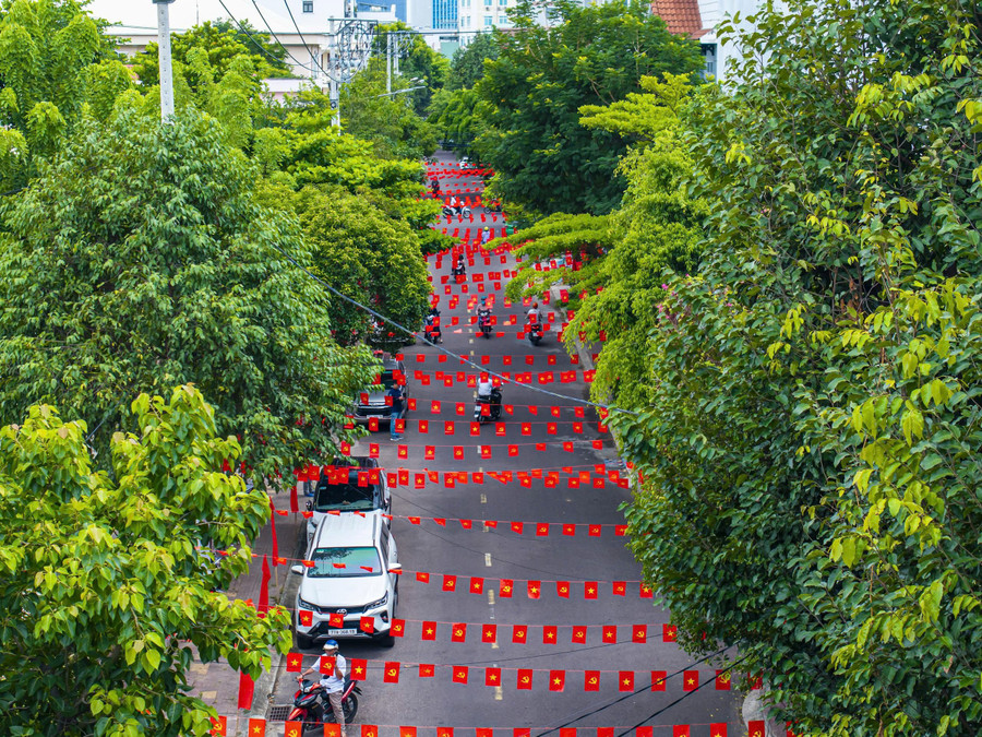 Aerial view of a street adorned with brilliant red flags with yellow stars. dungnhan2.jpg