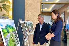 Delegates view several photographic works on display at the ceremony. Photo: Lam Nguyen