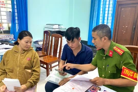 An Nhon Nam Ward police officers guide and assist residents in registering permanent residence for their children through the VNeID application. Photo: Nguyen Chon