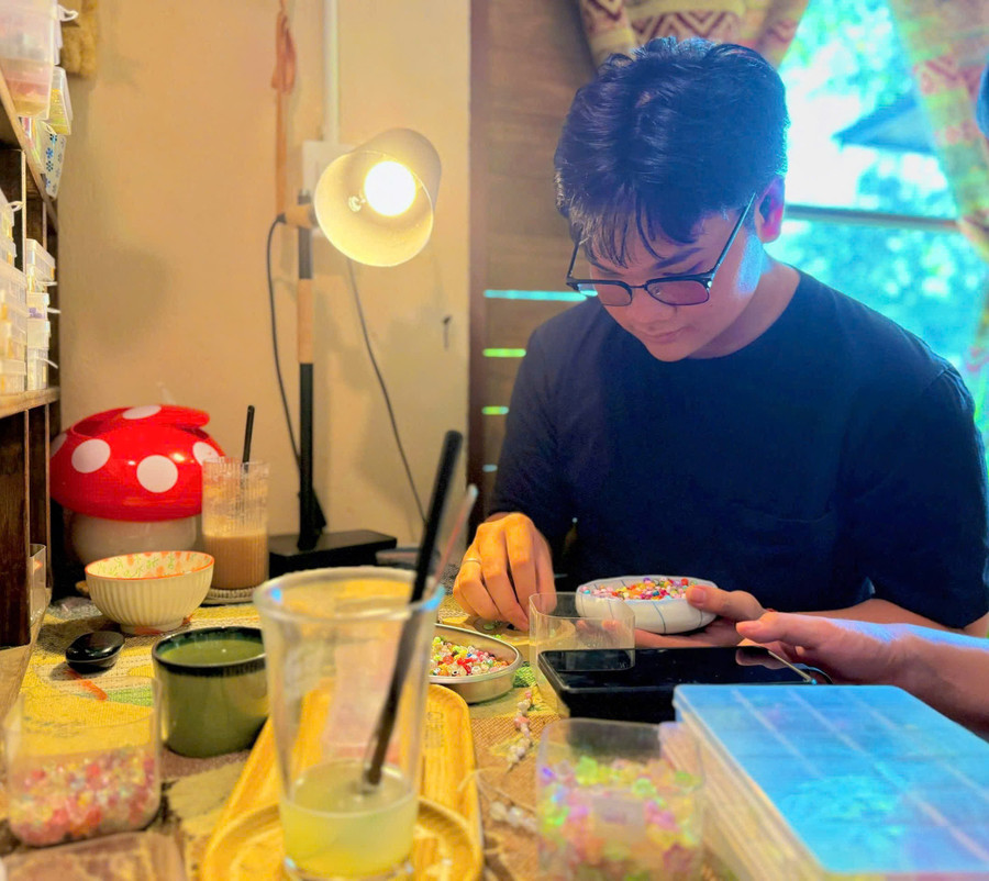 Trương Phúc An (student at Lê Lợi High School) uses his free time to make handmade bracelets for the girls on October 20th. Photo: Minh Thư an.jpg
