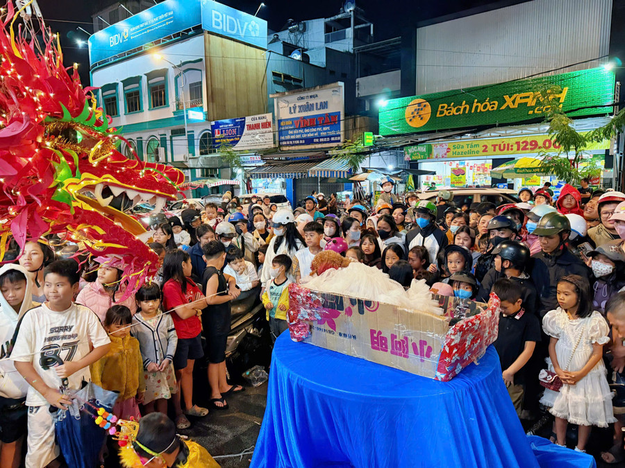 Crowds of locals and children gathered in front of Ms. That’s house to receive Mid-Autumn gifts and watch the lion dance. Photo: Minh Thu nhan-qua.jpg