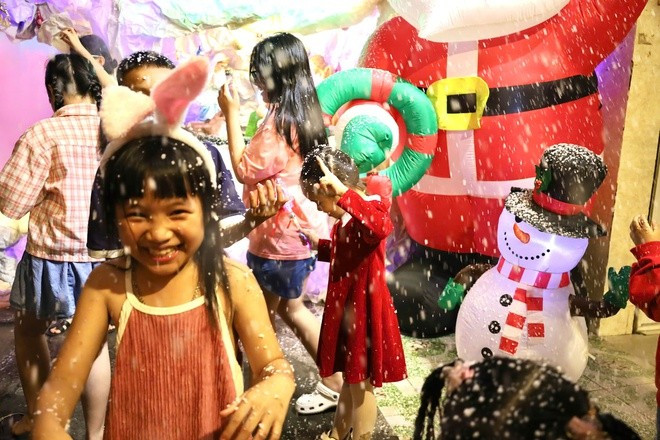 Children eagerly playing by the snow machines.