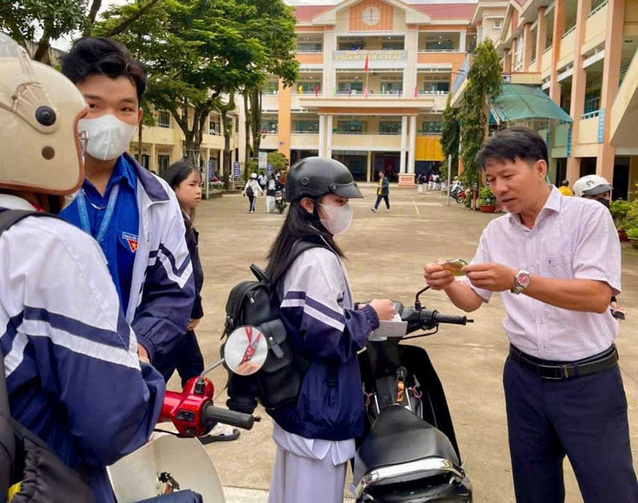 The rapid response team maintains order at the gate of Phan Boi Chau High School No. 2, checking and reminding students at the start and end of each school day. Đội xung kích giữ gìn trật tự trước cổng trường THPT số 2 Phan Bội Châu kiểm tra, nhắc nhở học sinh vào mỗi buổi học và tan trường. Ảnh: ĐVCC