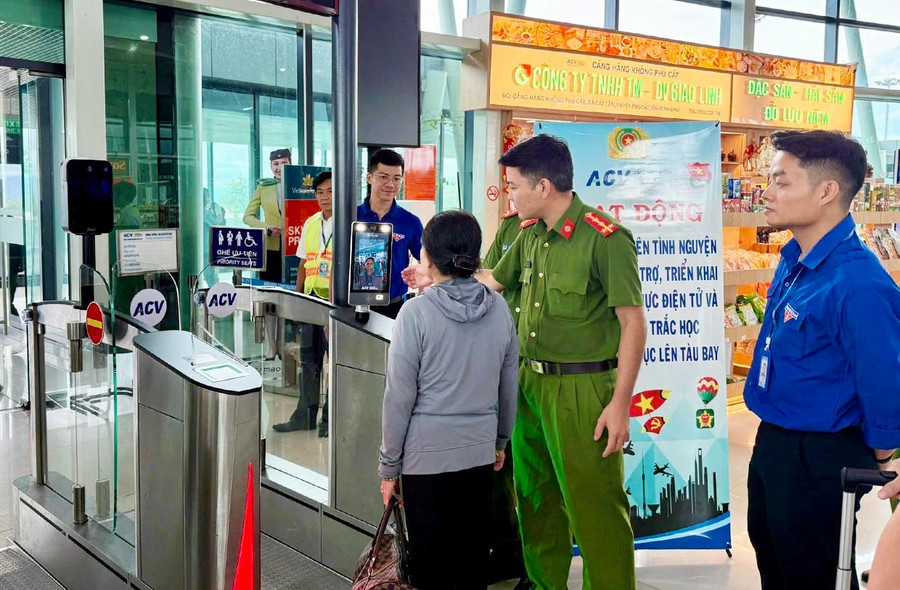 Youth union members and police officers guide elderly passengers on where to stand for the facial recognition (Face ID) system at the boarding gate at Phu Cat Airport. Photo: K.A Đoàn viên và Công an hướng dẫn hành khách là người lớn tuổi vị trí đứng để hệ thống nhận diện khuôn mặt (Face ID) ngay vị trí ra tàu bay tại Cảng hàng không Phù Cát. Ảnh: K.A