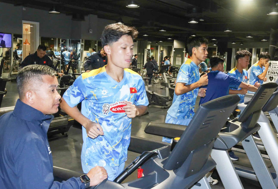 Coach Dinh Hong Vinh (far left) instructs Vietnam U23 players during a gym session. Photo: NVCC
