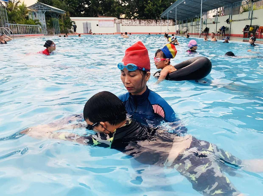Cô Trần Minh Hiệp hướng dẫn kỹ thuật bơi cho các em nhỏ. Ảnh: Vũ Chi