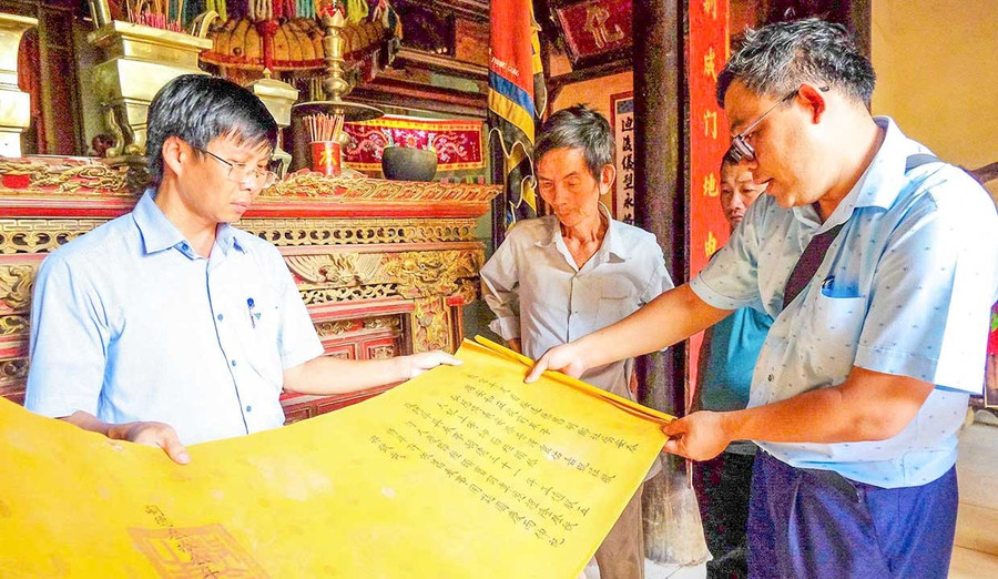 Tiến sĩ Võ Minh Hải (bìa phải) hiện cộng tác với Trung tâm Lưu trữ lịch sử tỉnh trong công tác dịch thuật, khảo cứu sắc phong và tư liệu Hán Nôm. Ảnh: Ngọc Nhuận