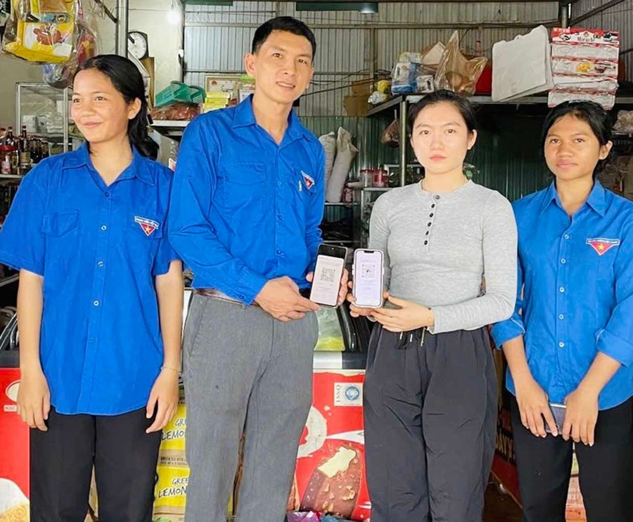 Tổ công nghệ số thanh niên xã Ia Pnôn hướng dẫn tiểu thương tạo mã QR thanh toán. Ảnh: Đoàn xã Ia Pnôn