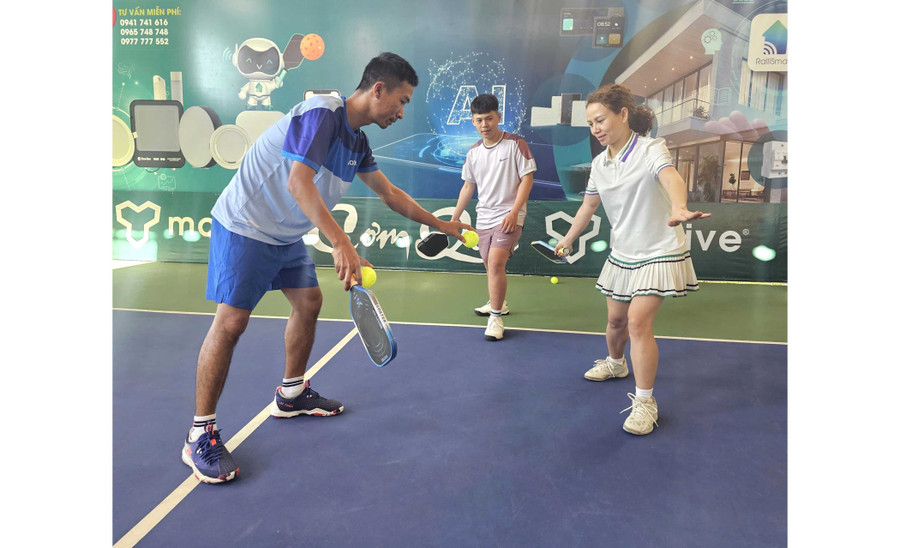 Coach Nguyễn Văn Hùng (left) instructs students in pickleball practice. Photo: R’Ô HOK