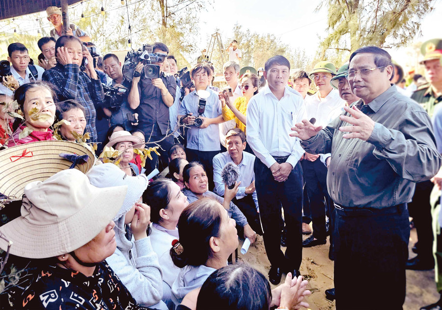 Thủ tướng Chính phủ Phạm Minh Chính trò chuyện với nhân dân xã Đề Gi trong chuyến kiểm tra tình hình khắc phục hậu quả cơn bão số 13. Ảnh: N.H