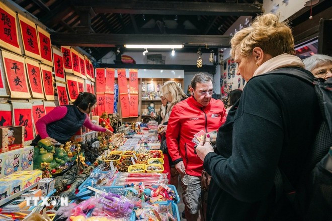 Foreign visitors shopping for souvenirs in Hanoi. (Photo: Pham Tuan Anh/VNA)