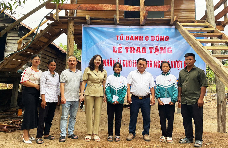 Teacher Vu Van Tung (third from right, representative of the Zero Dong Bread Cabinet) presents a charity house and scholarships to Nay H’Ngan (second from right) and Ksor H’Nhi (fourth from right). Photo: Vu Chi