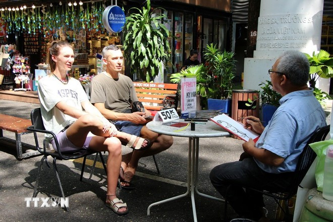 International visitors experience portrait sketching services on Nguyen Van Binh Book Street, a popular tourist spot in downtown Ho Chi Minh City. (Photo: Nguyen Hang/VNA)