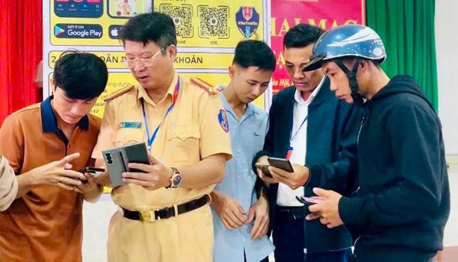 Traffic police officers instruct citizens on how to install and use the features of the VNeTraffic application. Photo: ĐVCC