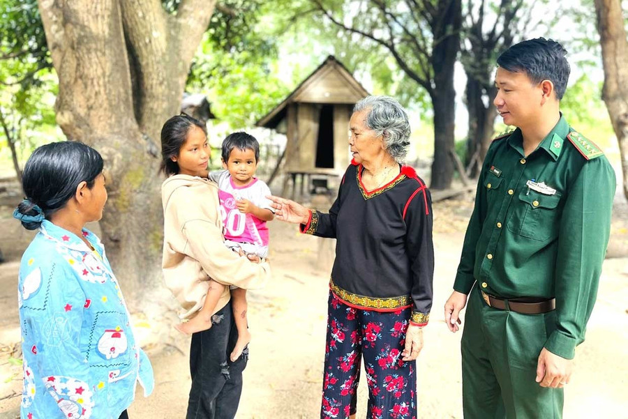 Elder Ksor H’Blâm (second from right) visits villagers with Border Guard officers. Photo: Phương Dung Già làng Ksor H’Blâm (thứ 2 từ phải sang) cùng Bộ đội Biên phòng thăm người dân trong làng.