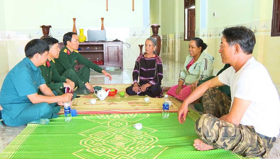 Elder Siu Phyin (fourth from left) talks with officers from the Area 4 Defense Command—Chư Prông, along with local officials, militia, and residents of Ia Púch commune. Photo: Phương Dung Già làng Siu Phyin (thứ 4 từ trái sang) trò chuyện cùng bộ đội Ban Chỉ huy Phòng thủ khu vực 4 - Chư Prông và cán bộ, dân quân, người dân trong xã Ia Púch.