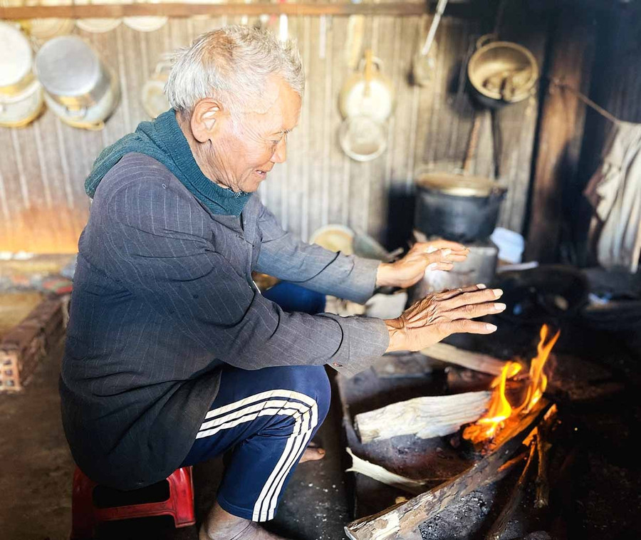 Mr. Siu Heol by the fire, sharing the beauty of the firewood-giving custom. Photo: P.D