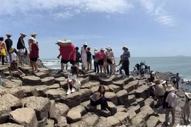 Tourists visit Ghenh Da Dia, a natural rock formation in Tuy An Dong Commune, Dak Lak Province.